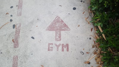 A sign pointing toward a gym entrance similar to how seo points traffic to gym websites.
