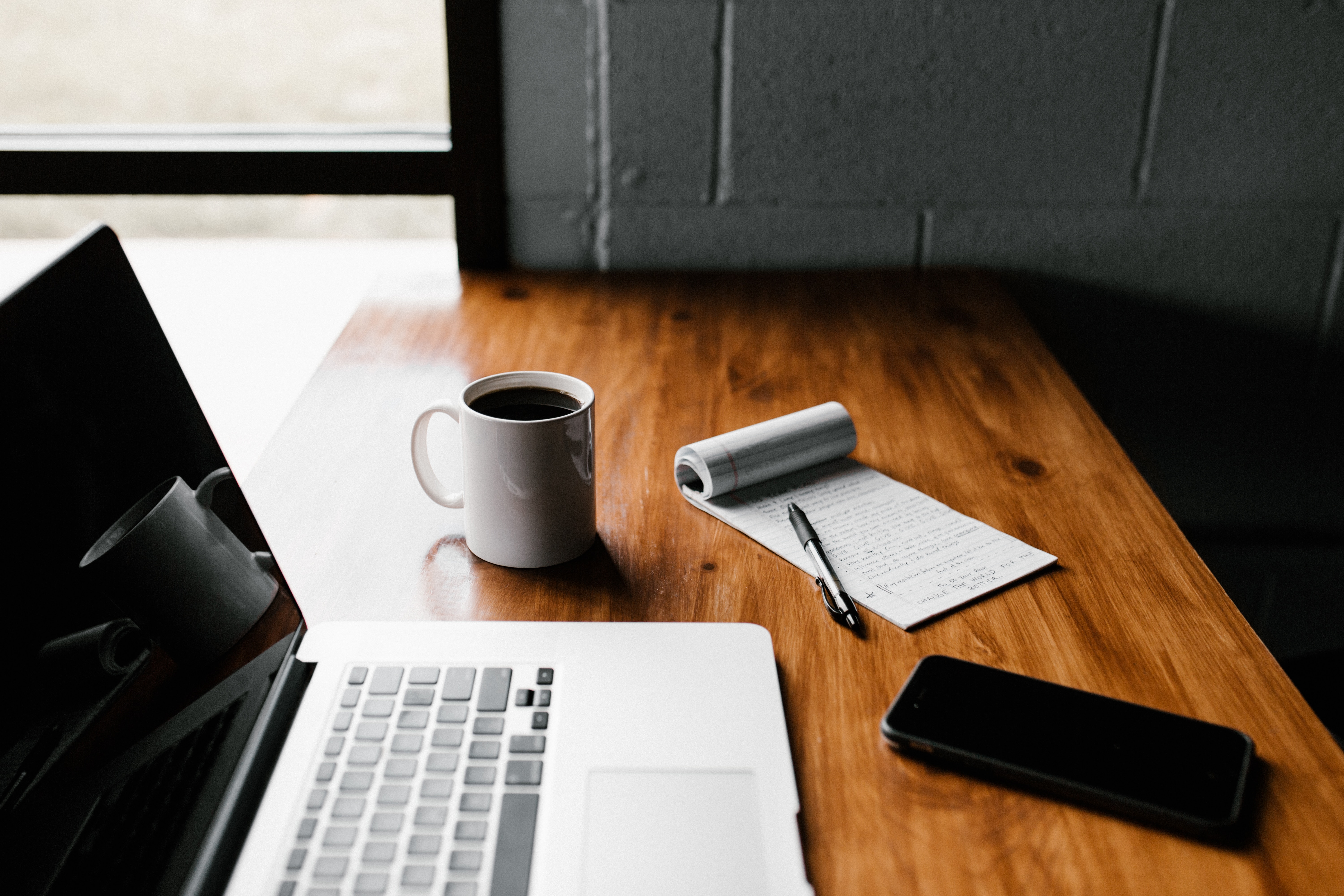 Blog post ideas for swimming pool service business displayed on a laptop with a coffee cup.