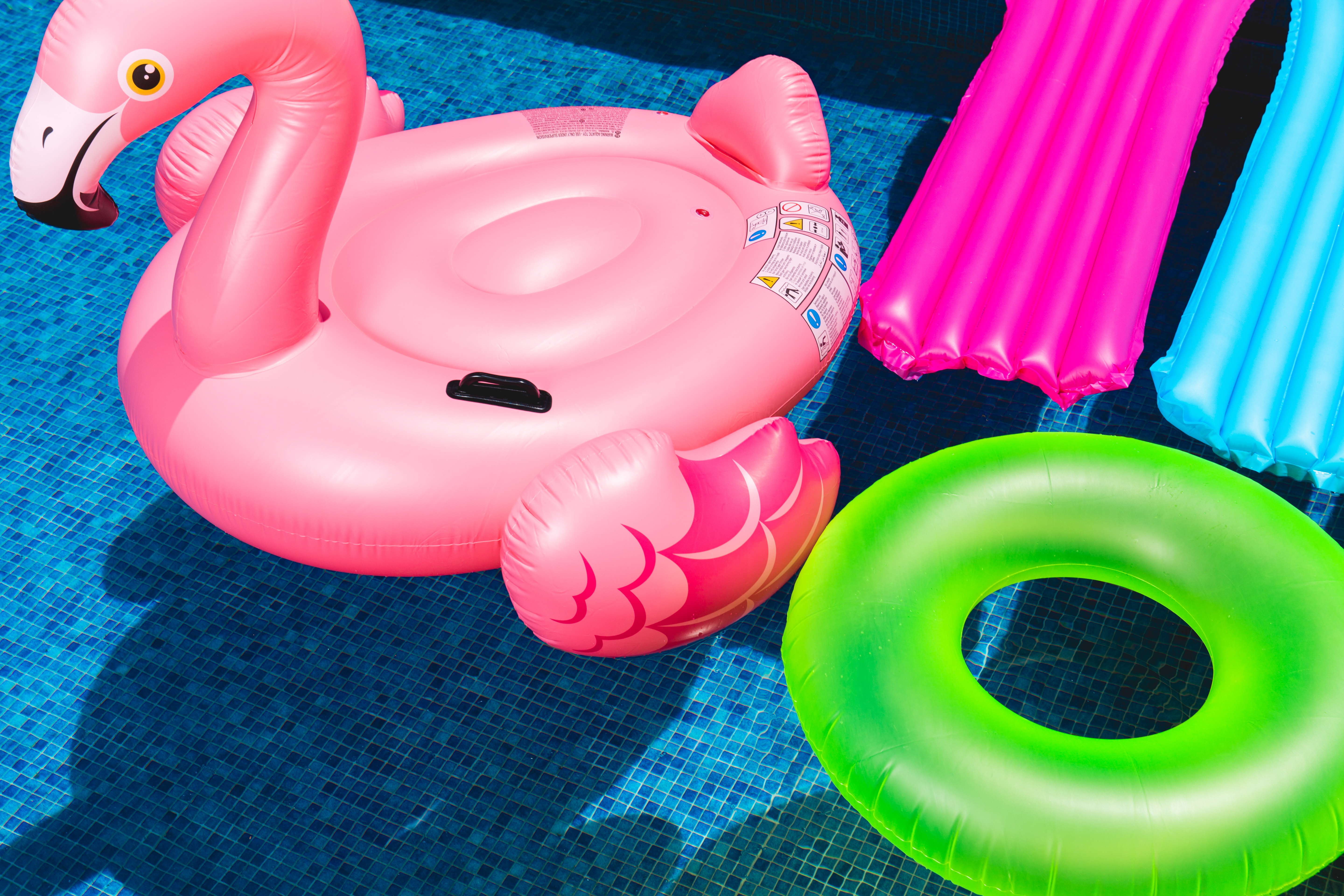 Swimming pool SEO essentials featuring a pink flamingo float and another pool float.