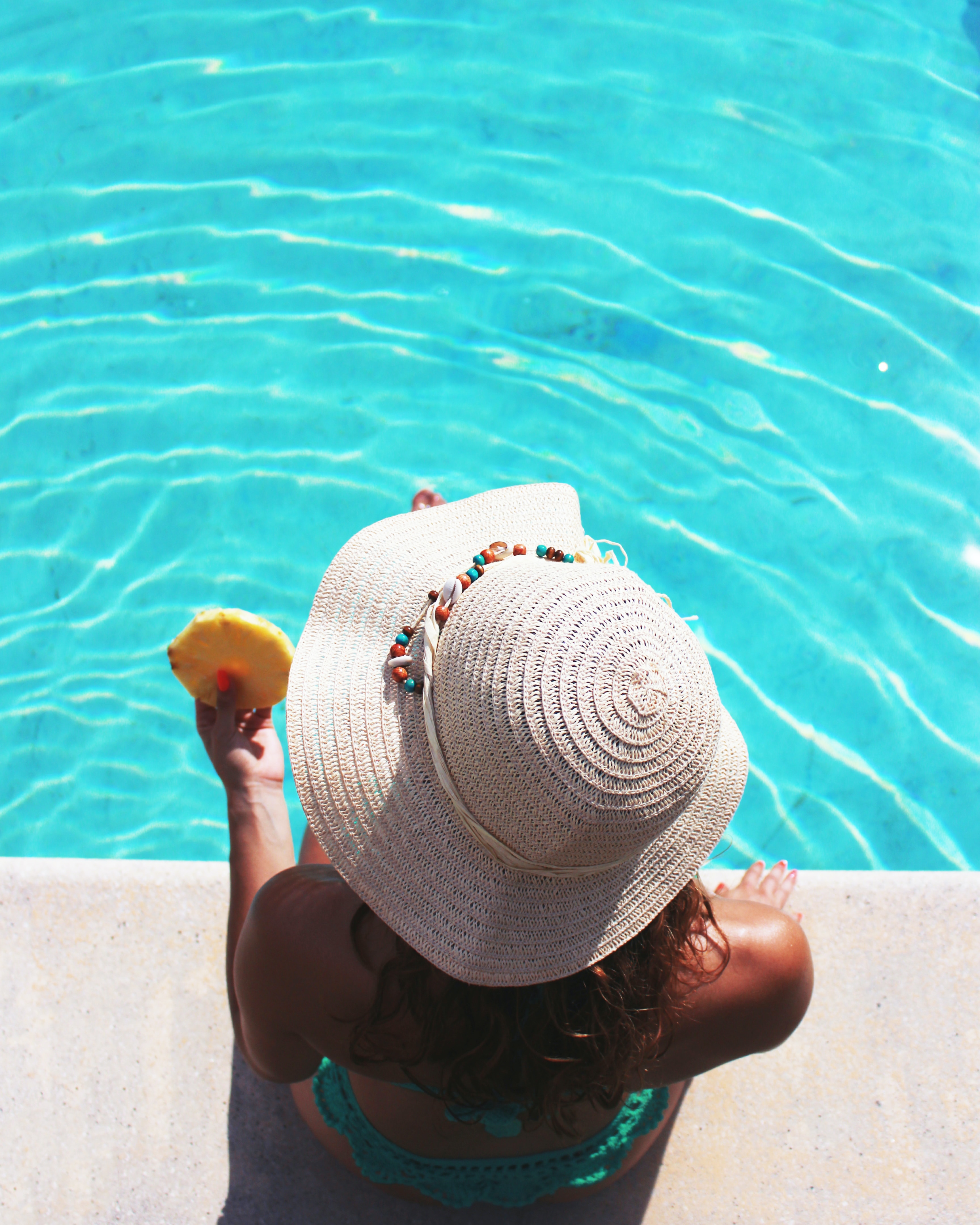 Woman relaxing poolside, aided by our top-notch swimming pool service.