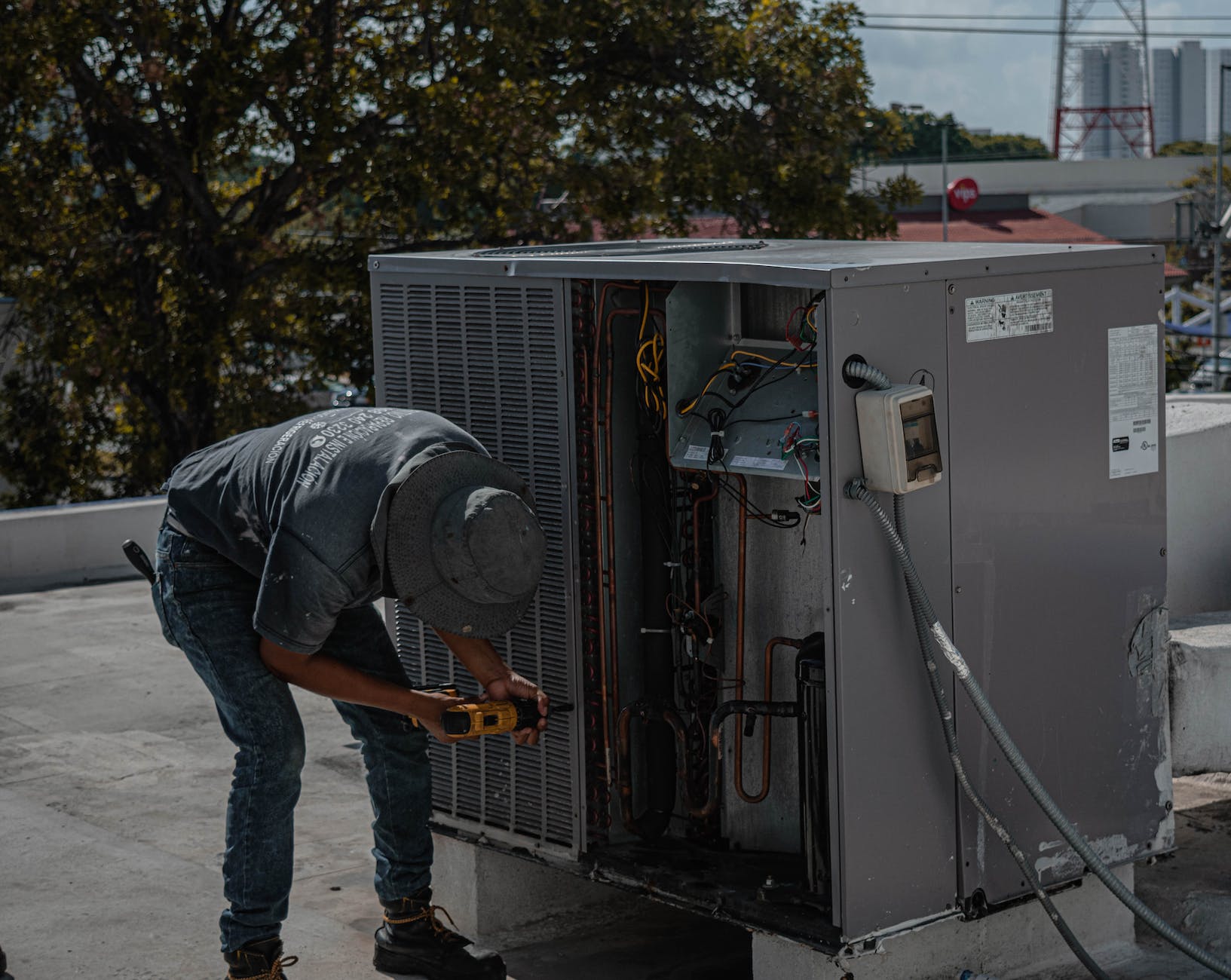 HVAC technician improving local search ranking by fixing an air conditioner on a roof.