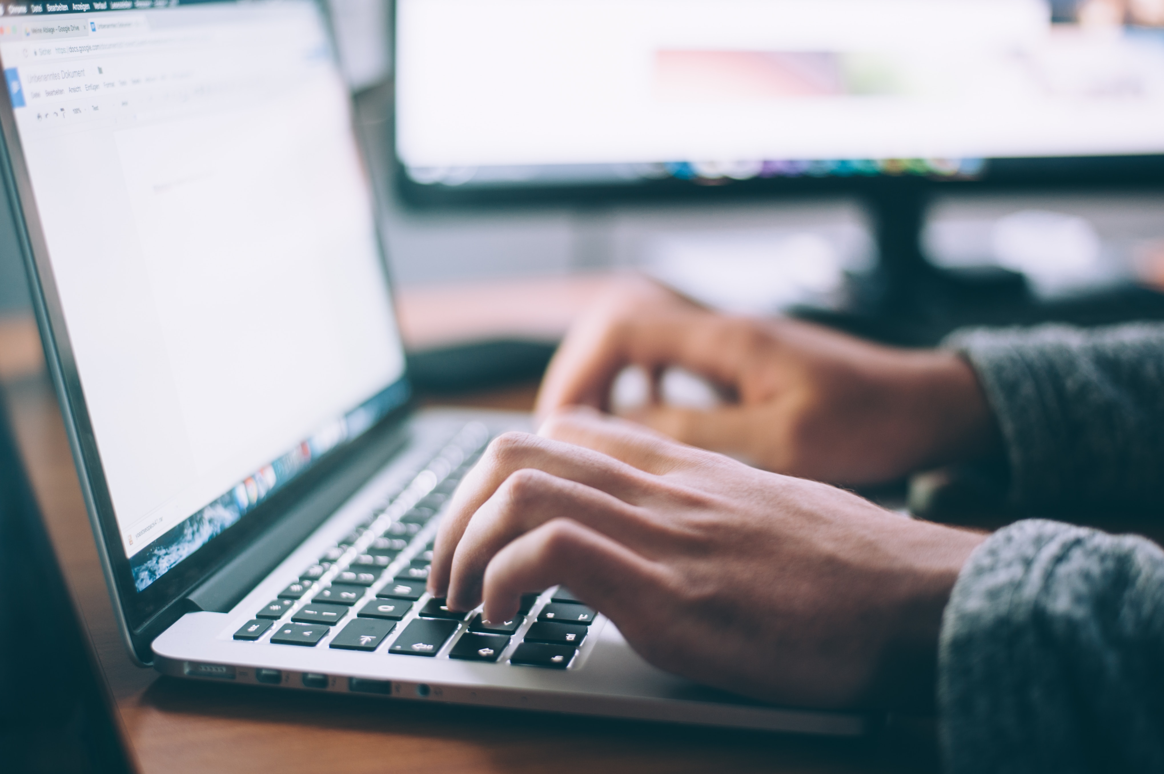 Person crafting SEO optimized articles for a pool business website on a laptop.
