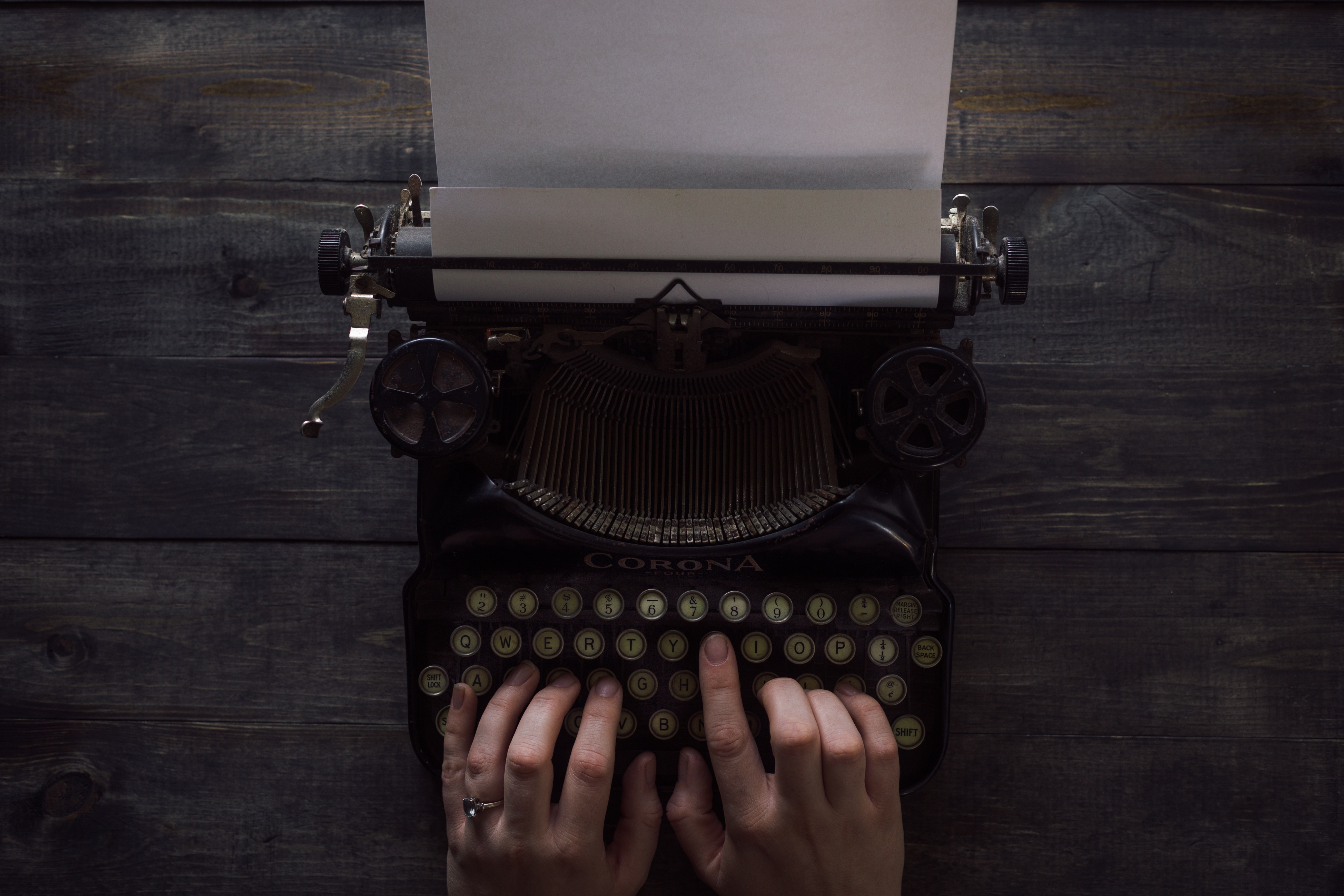 Woman using typewriter for SEO article writing services for pest control businesses