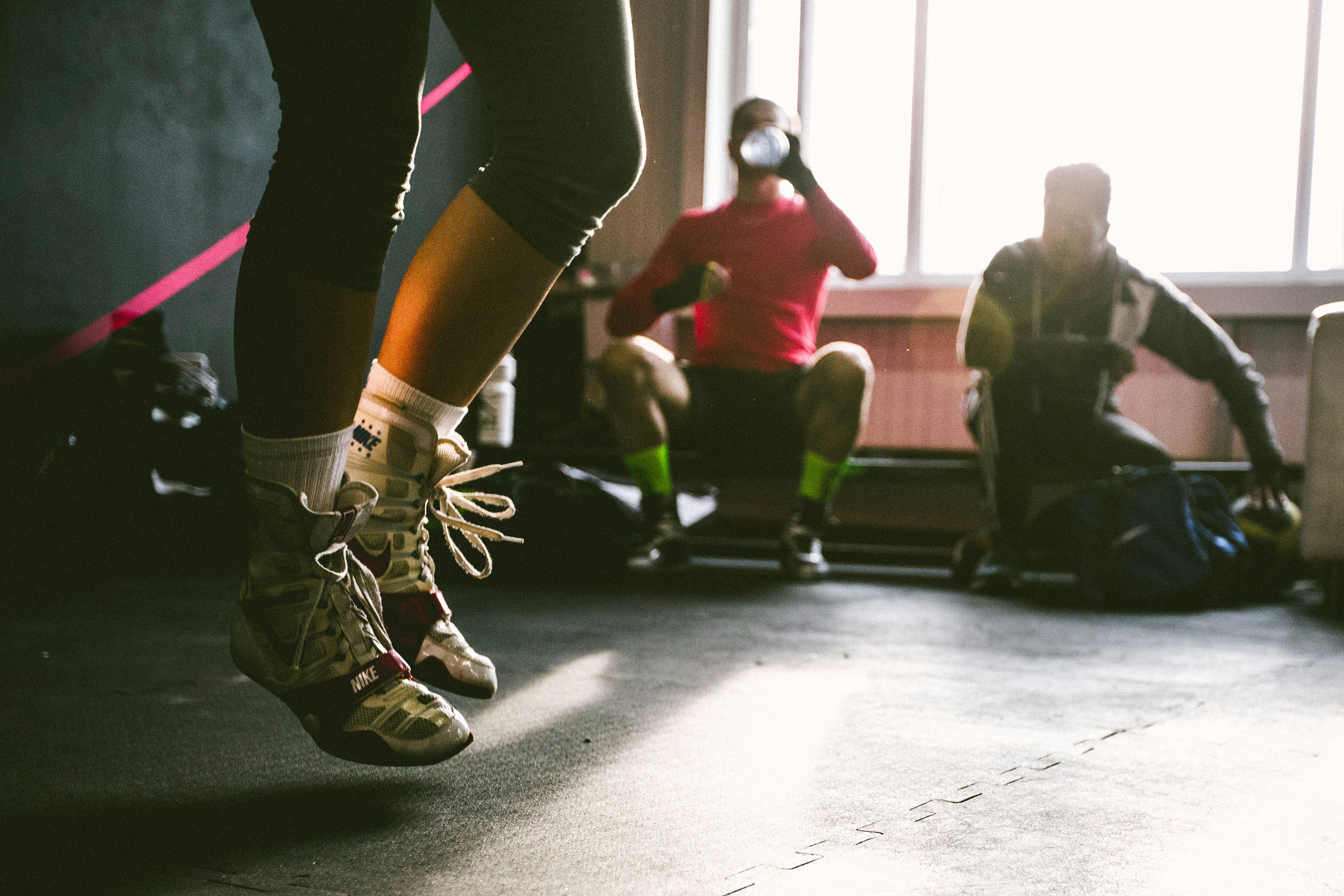 Woman jumping in gym, embodying tips for increasing fitness business authority.
